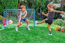 Lifestyle image of the Little Tikes Sports Game Kit: 2 kids' playing soccer outdoors