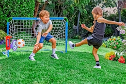 Lifestyle image of the Little Tikes Sports Game Kit: 2 kids' playing soccer outdoors