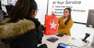 macys customer service cashier handing order pickup bag to customer