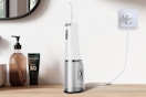 a water flosser charging on a wooden table