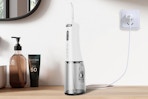 a water flosser charging on a wooden table