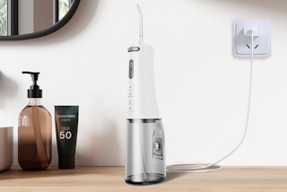 a water flosser charging on a wooden table