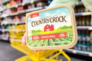 hand holding country crock spread with shopping cart in background