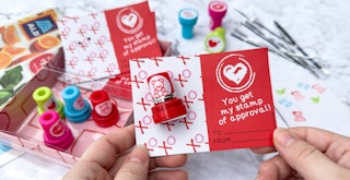 Someone working on putting together the cards from the Aldi Valentine's day Stamper kit on a counter