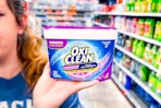 person holding a container of OxiClean powder