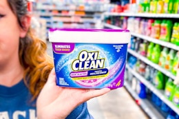 person holding a container of OxiClean powder