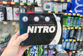 nitro golf balls in box held in front of other golf items