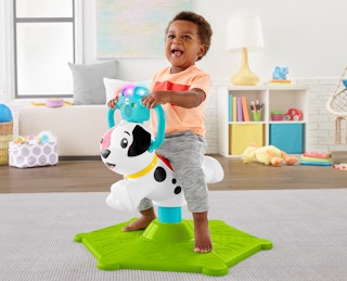 stock photo of toddler playing on fisher-price bounce and spin interactive puppy with lights and sounds with childs play room in background
