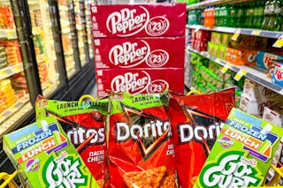 cases of dr pepper soda, doritos, and gogurt in a cart
