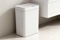a trash can near a sink