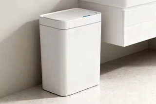 a trash can near a sink