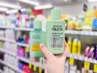 hand holding two garnier fructis hair filler products