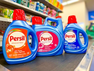 three bottles of persil liquid detergent on walmart conveyor belt