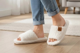 Lifestyle image of a woman wearing a pair of the white Ecetana House Slippers in home setting (close up shot)