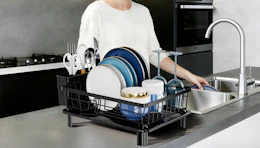 a drying dish rack on a kitchen counter with dishes inside