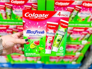 hand holding a pack of colgate max fresh fruity toothpaste