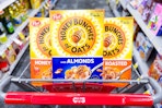 3 boxes of honey bunches of oats cereal in a cart