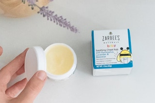Person removing lid Zarbee's Baby Chest Rub