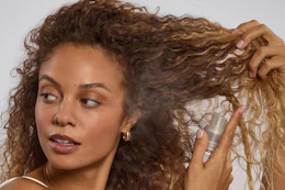 a woman using kitsch dry shampoo