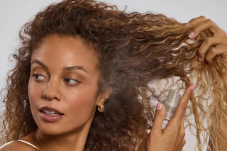 a woman using kitsch dry shampoo