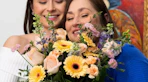 two people looking at a bouquet of flowers