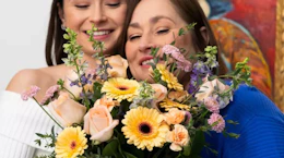 two people looking at a bouquet of flowers