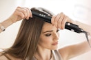 a woman straightening her hair