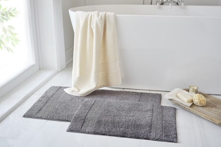 Bath rugs in front of a bathtub
