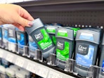 hand pulling a Dove Men+Care deodorant off a Walmart shelf