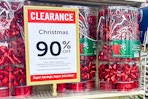 containers of holiday bows and gift wrap on hobby lobby end cap during 90% off holiday clearance