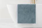 a grey bath mat on a bathtub