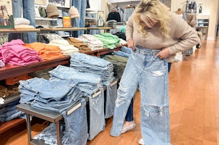 a woman trying on jeans in American Eagle