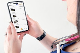 a woman with a cellphone with the fetch app rewards on screen