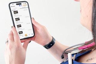 a woman with a cellphone with the fetch app rewards on screen