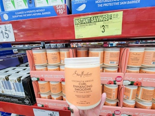 hand holding a tub of shea moisture curl enhancing smoothie cream