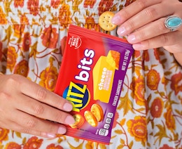 a person holding a snack bag of cracker sandwiches 