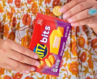a person holding a snack bag of cracker sandwiches 