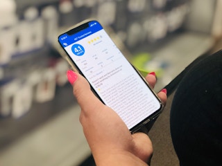 hand holds phone open to best buy app and reviews in the app