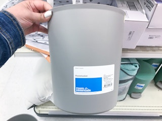hand holding a room essentials wastebasket at target