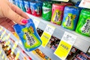 person holding a container of trident gum by the display