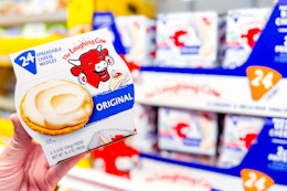 hand holding a pack of the laughing cow cheese wedges