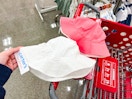 hand holding a carter's sun hat in front of a parked target cart