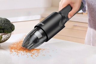 Person using the handheld vacuum on kitchen counter