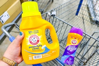 hand holding arm & hammer detergent with scent booster in walmart cart