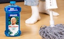 a bottle of cleaner on the floor next to a mop