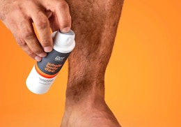 a person spraying whole body deodorant on their feet