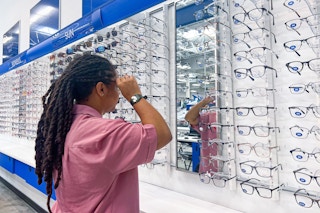 a person trying on glasses inside of sams club