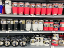 A shelf at Dick's sporting goods stocked with Yeti brand beverage containers, including Rambler 20oz tumblers, Rambler 14oz mugs, and ...
