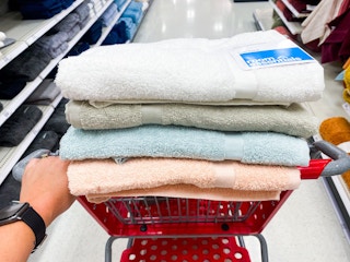 Room essentials bath towels in a Target shopping cart in the towel aisle