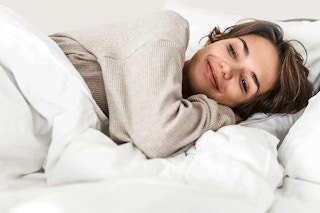 A woman sleeping under a comforter